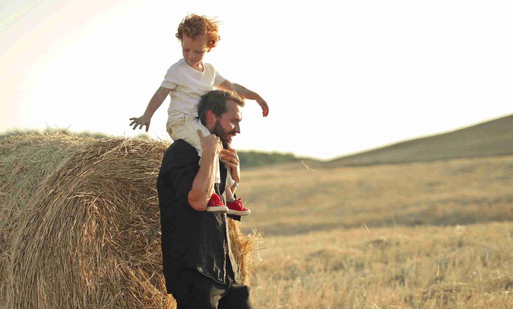 father-giving-son-piggyback-ride-in-field